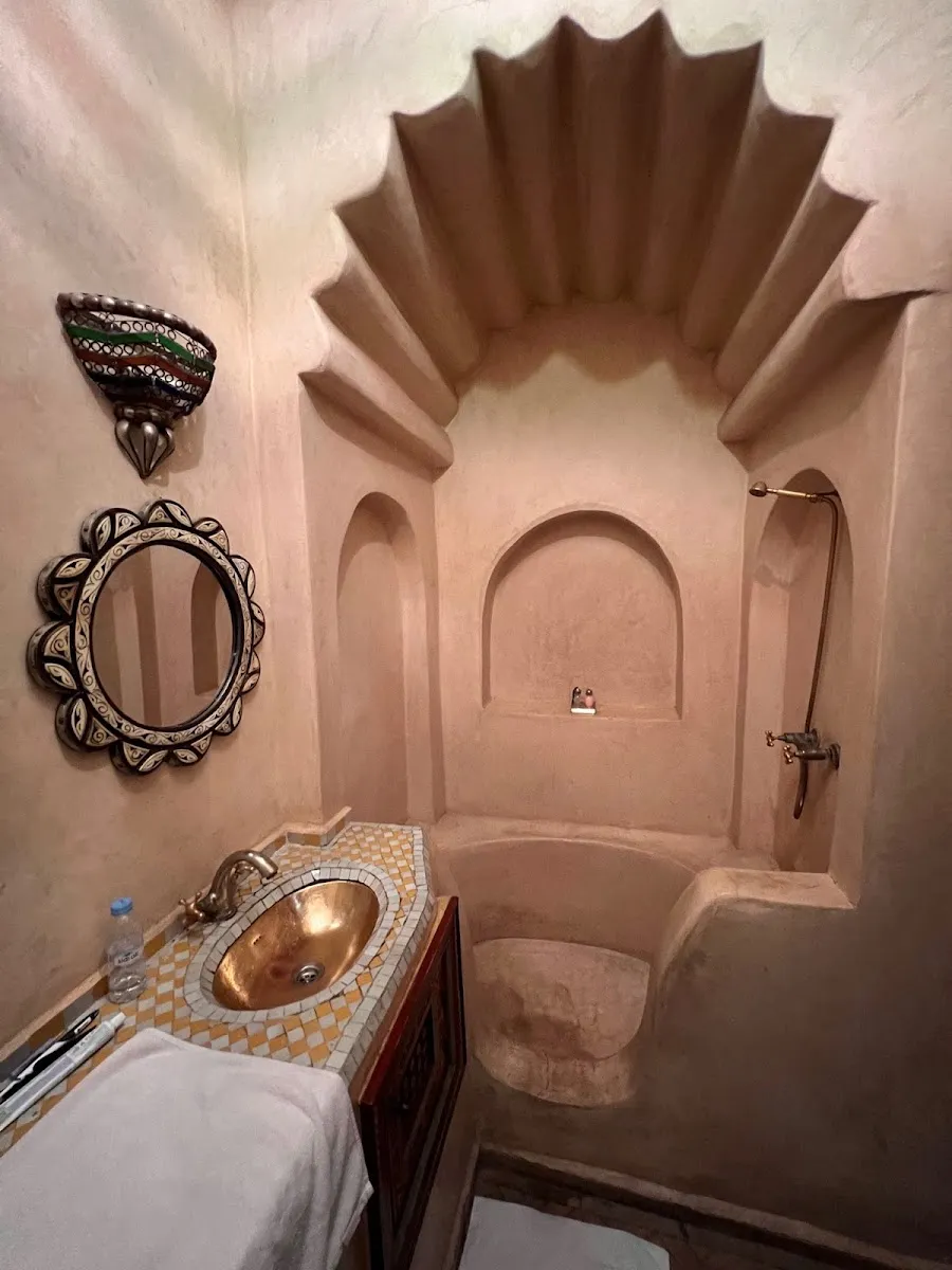 A tadelakt bath niche under a hand-sculpted shell arch
