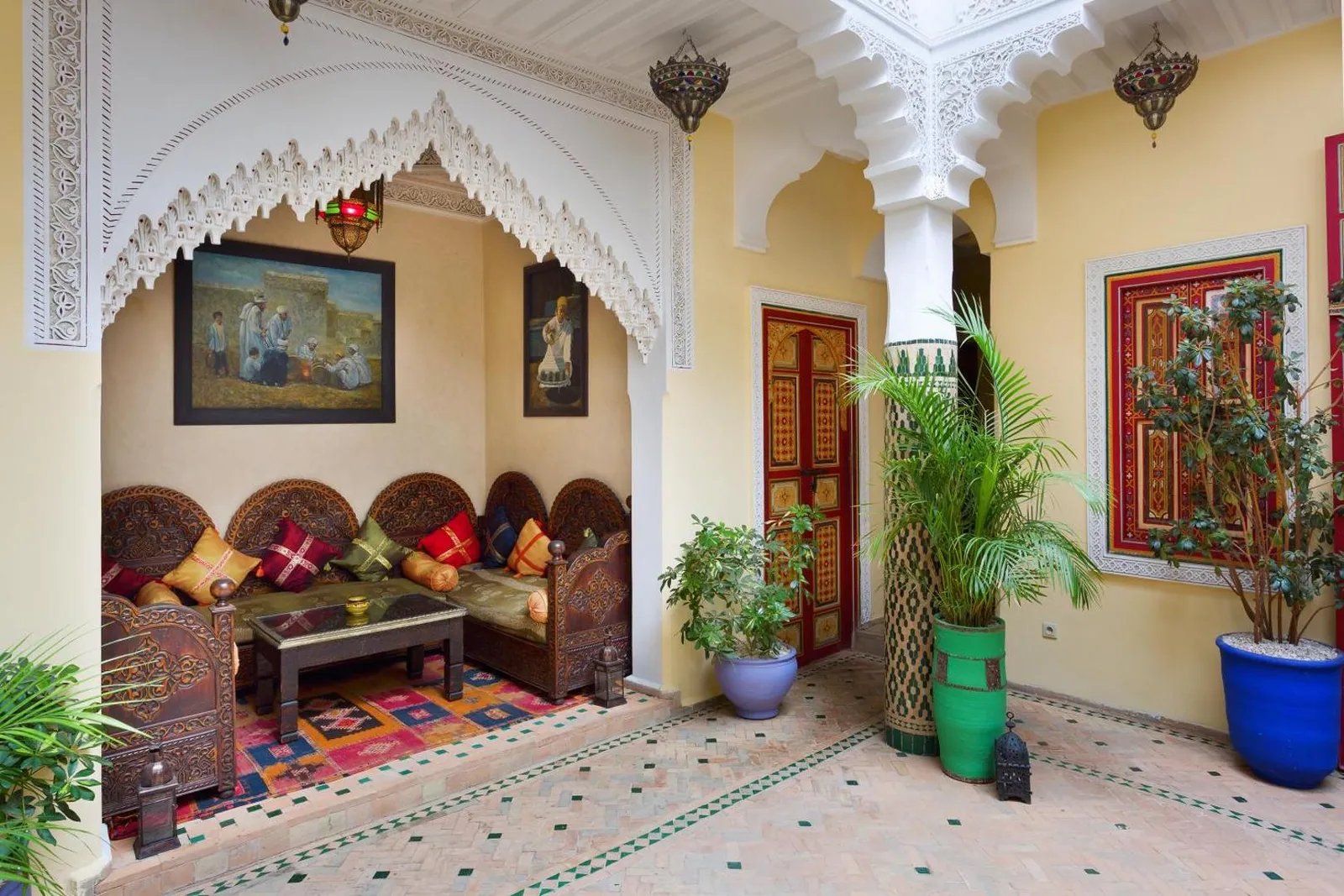 The sculpted white plaster arcade of the courtyard, painted doors behind