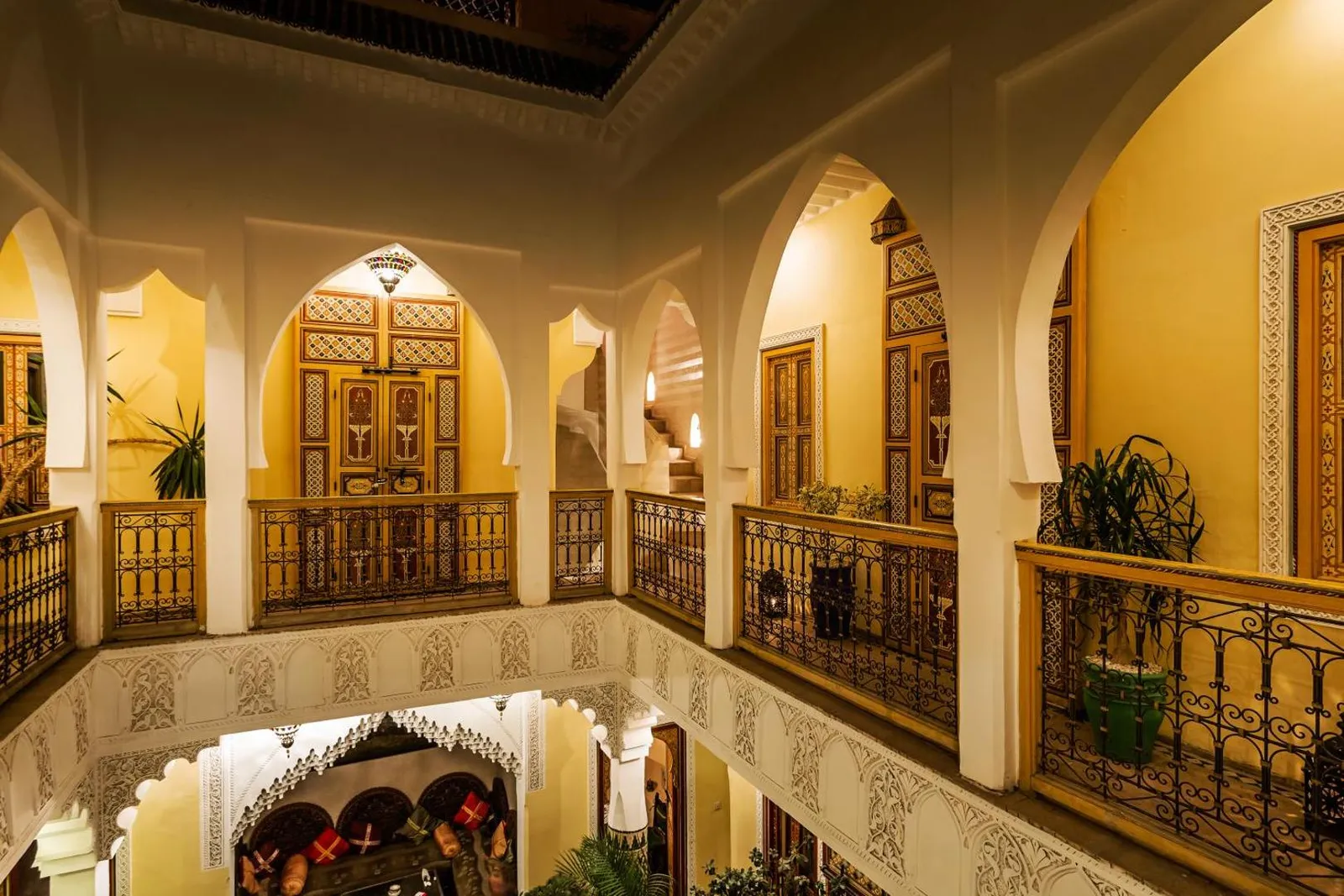 The gallery at night, lanterns lit along the arcades