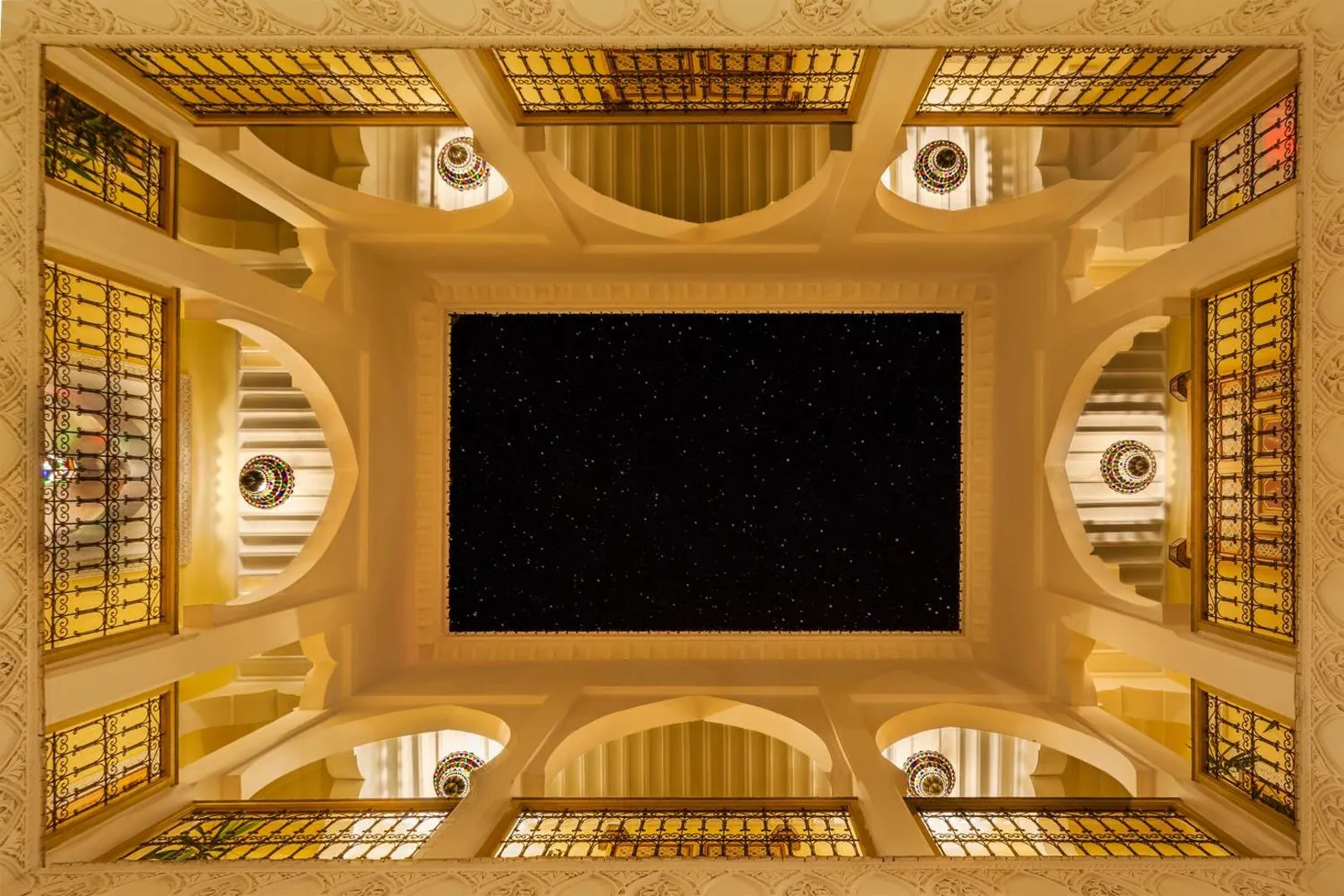 Looking up at the carved ceiling and the open sky of the courtyard