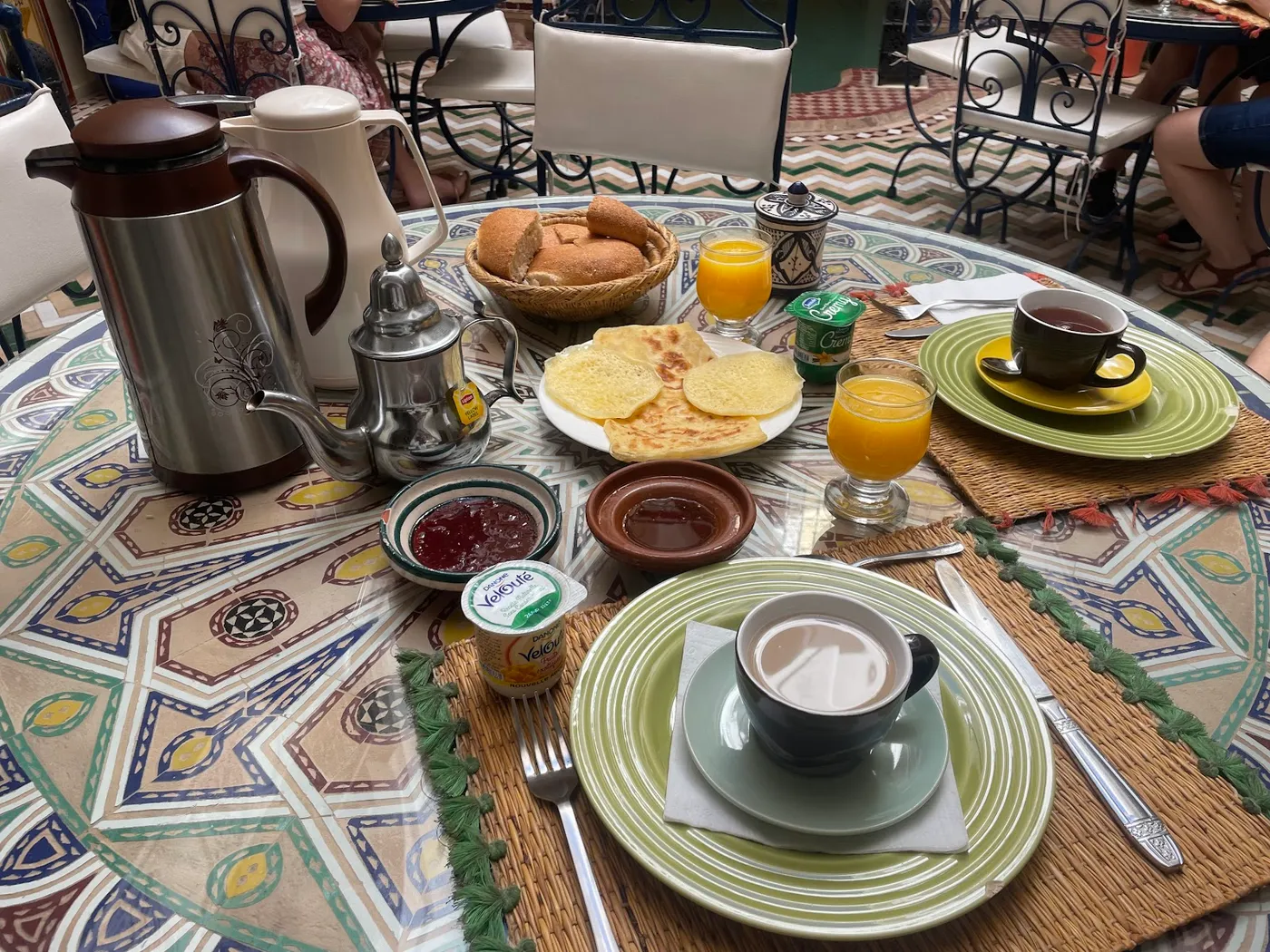 A breakfast tray with mint tea, breads and fresh juice at the riad