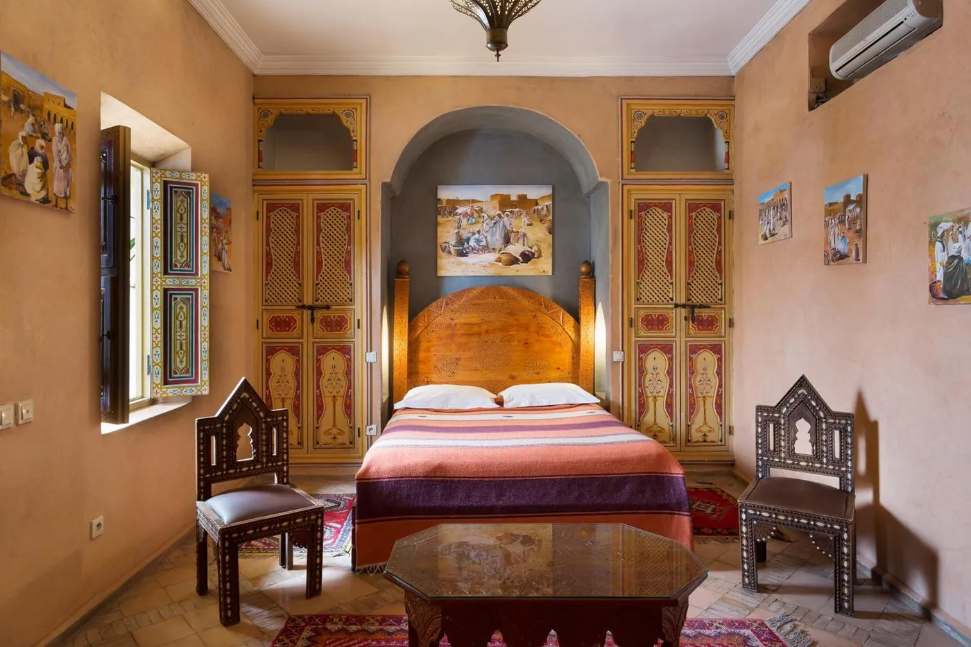 A bed set into a carved and painted wooden alcove