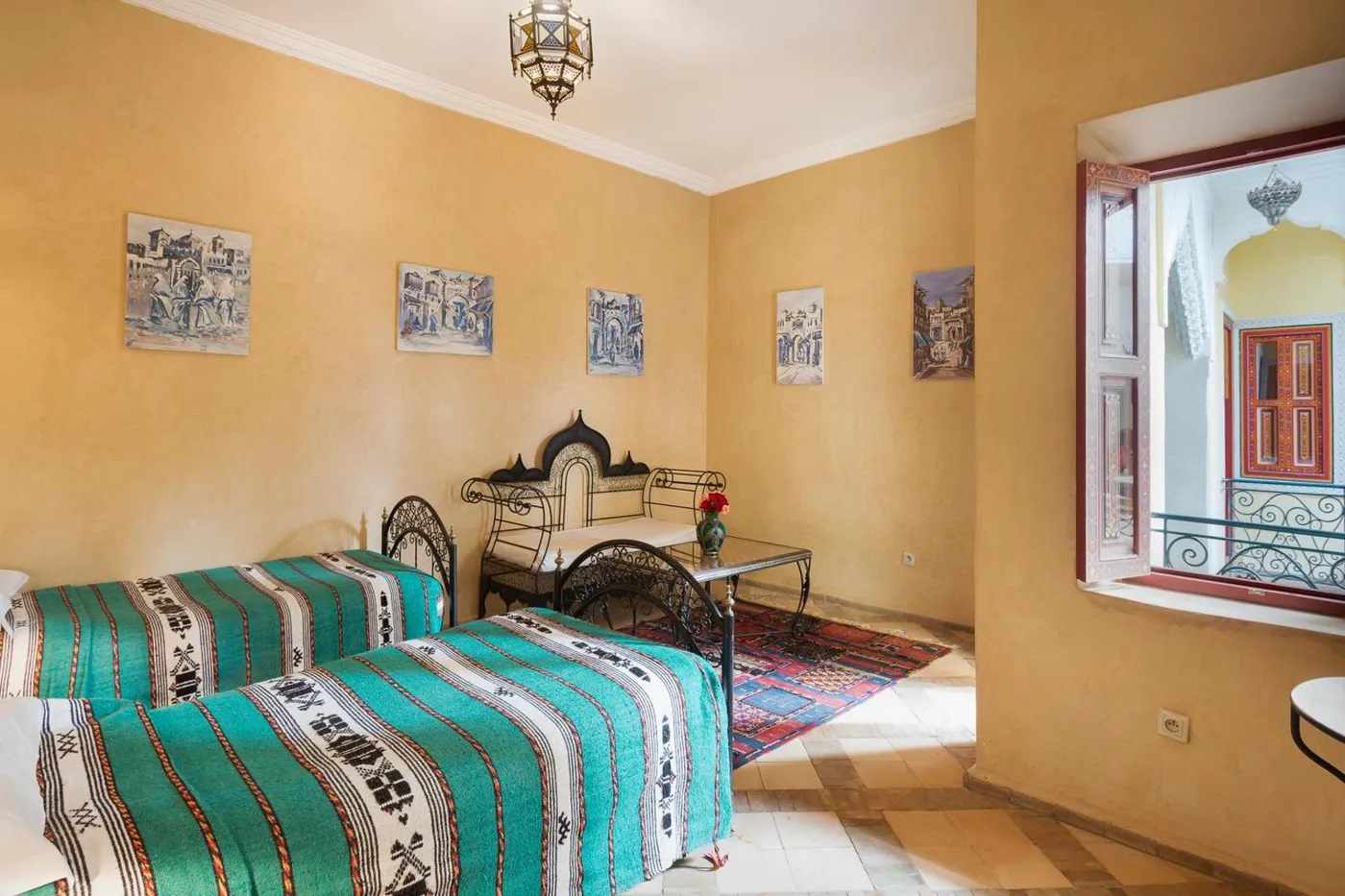 A wrought-iron bed with a teal striped blanket