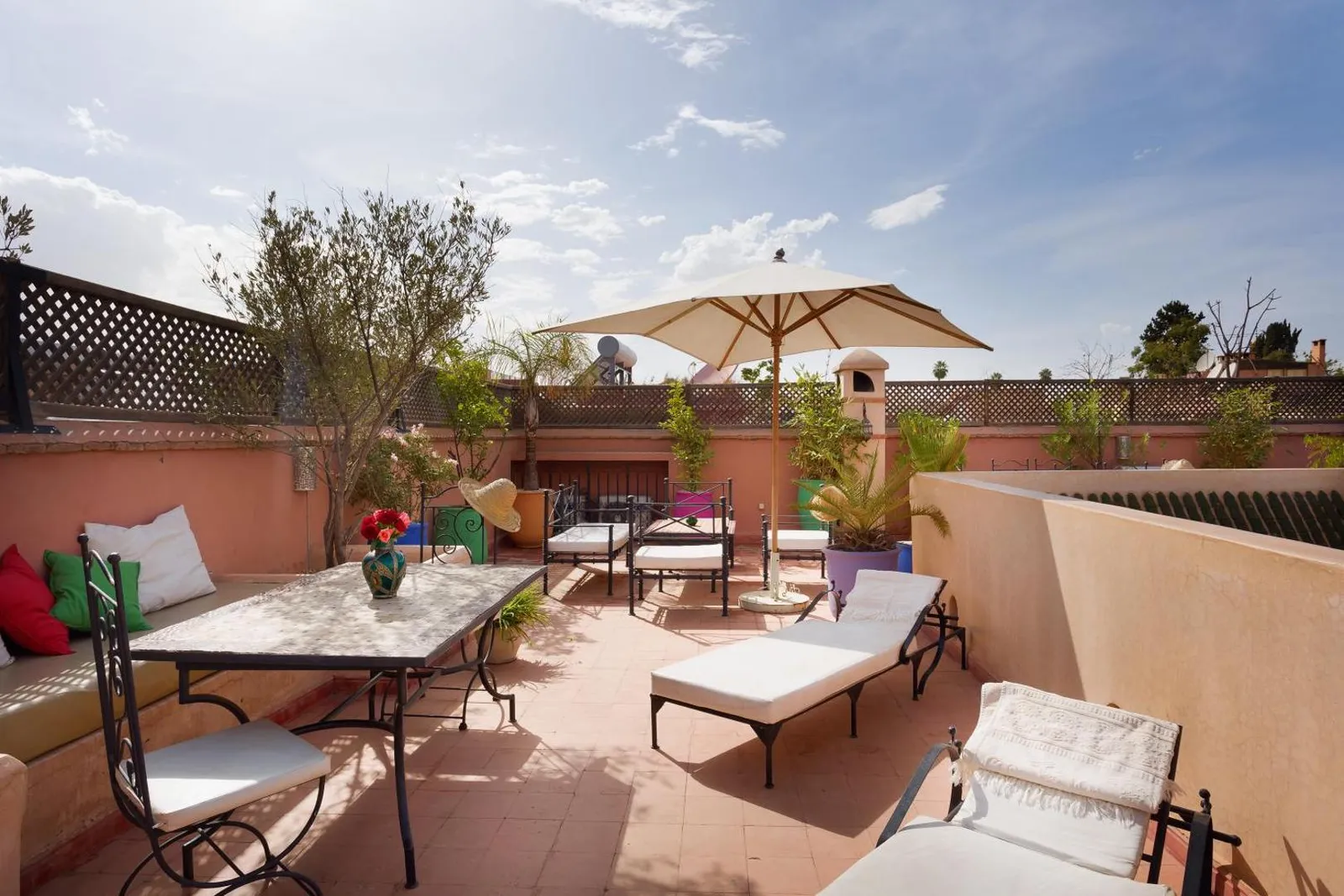 The rooftop terrace of Riad Sofia over the medina rooftops, parasol open in the morning light